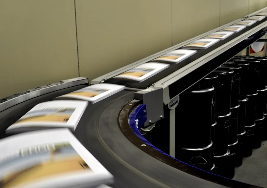 Softcover books moving on a conveyor belt in a book manufacturing facility