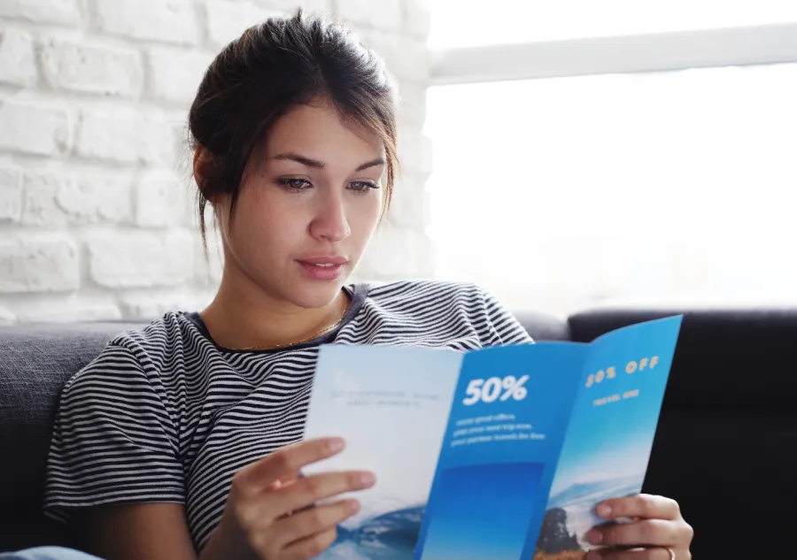 A young woman reading a tri-fold brochure