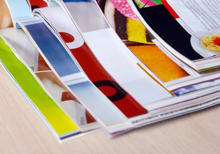 A stack of open magazines with Aqueous Coating applied to the pages