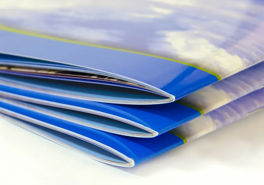 A stack of Saddle-Stitched books with Gloss UV Coating on the covers