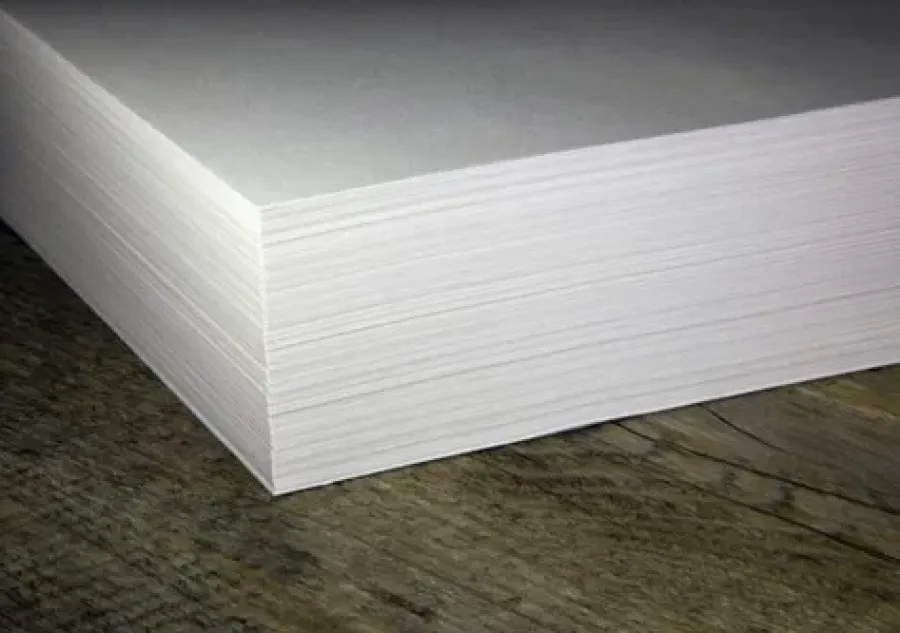 A stack of white paper lying on a wooden surface