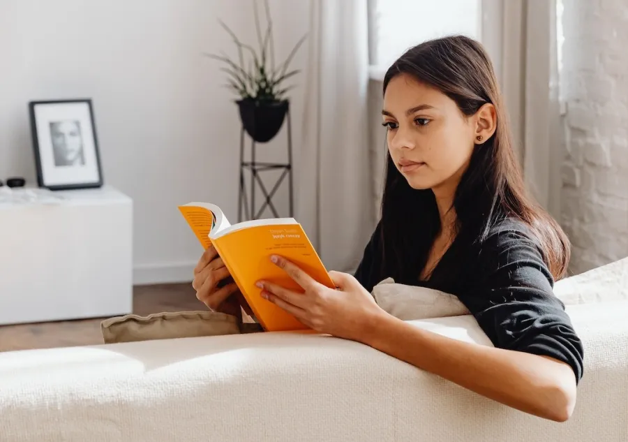 A young woman reading a Perfect Bound book