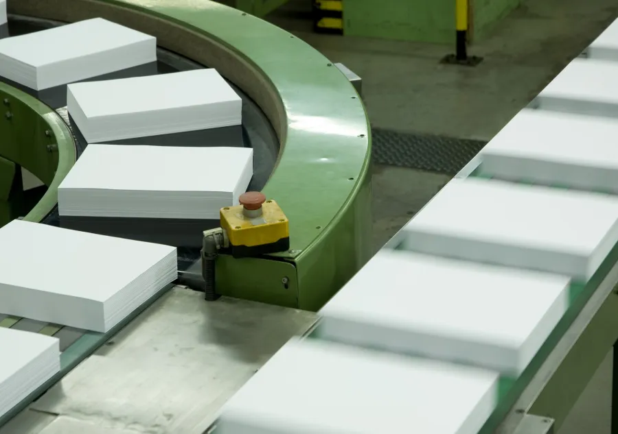 Stacks of cut paper sheets moving along a conveyor