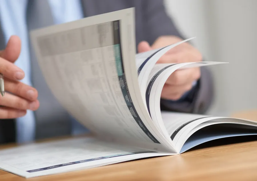 A person flipping through a Saddle Stitched Booklet