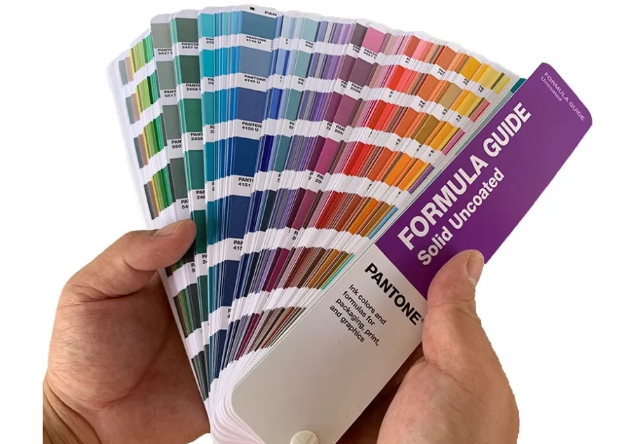 Two hands holding a Pantone Color Guide