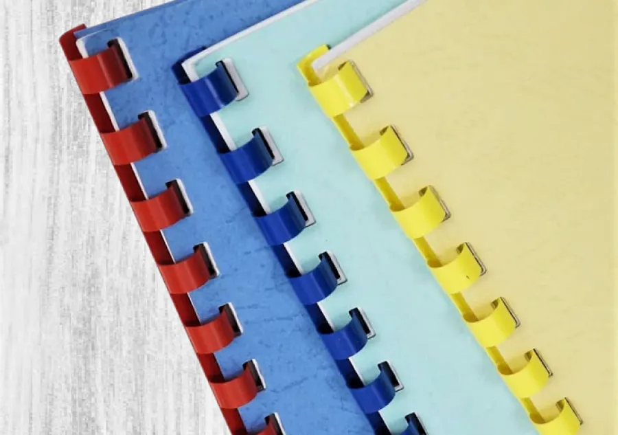 Three Comb Bound books with red, blue, and yellow spines