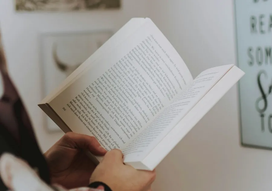 a person holding open a perfect bound book