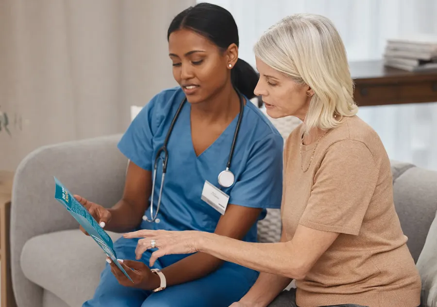 A female nurse and a female patient reviewing an informational pamphlet