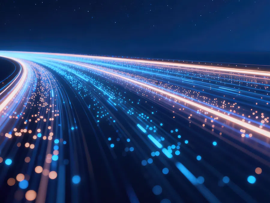 Curved streams of blue and orange glowing fiber optic light lines over dark background symbolizing data flow.