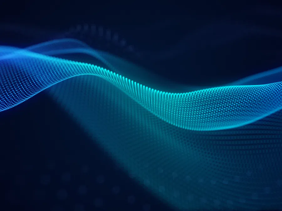 Flowing blue digital wave made of particles on a dark background representing technology and data.