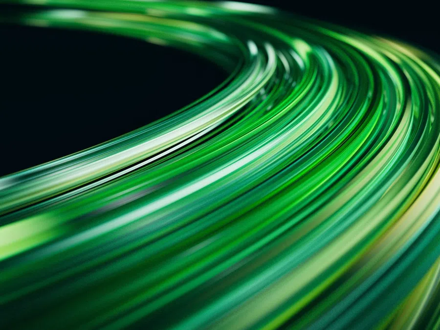 Abstract curved streaks of green light on a dark background creating a dynamic flowing motion effect.
