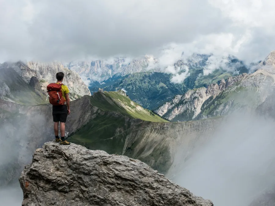 a man standing on a rock above a waterfall