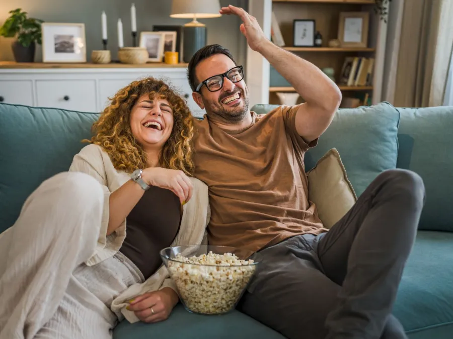 a man and woman sitting on a couch and smiling