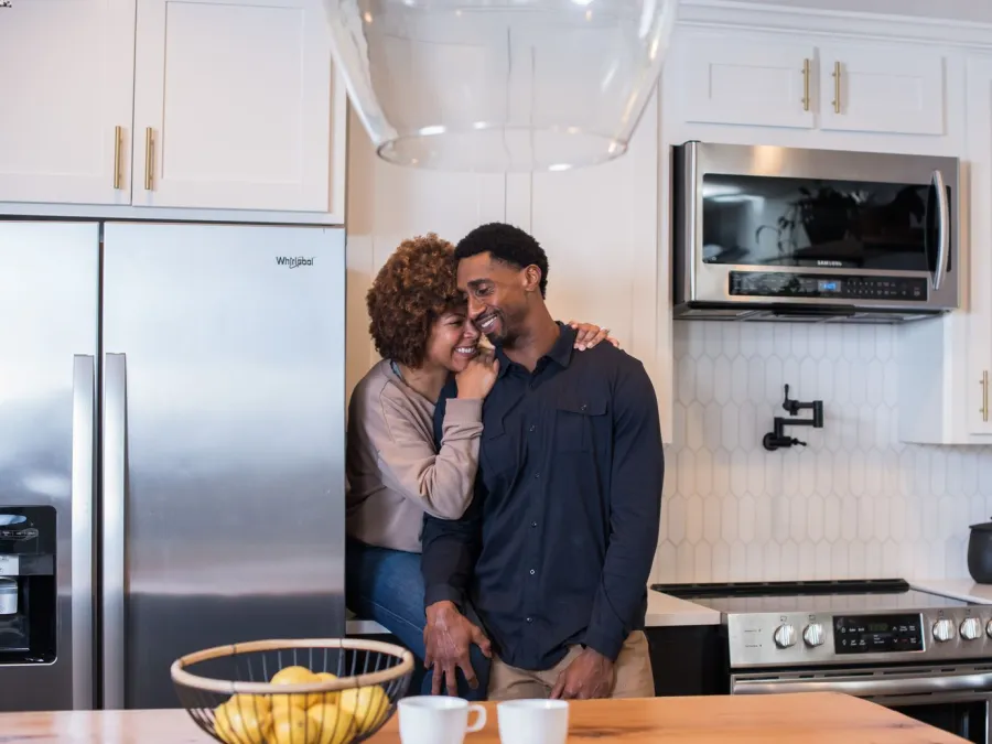 a man and woman hugging in a kitchen