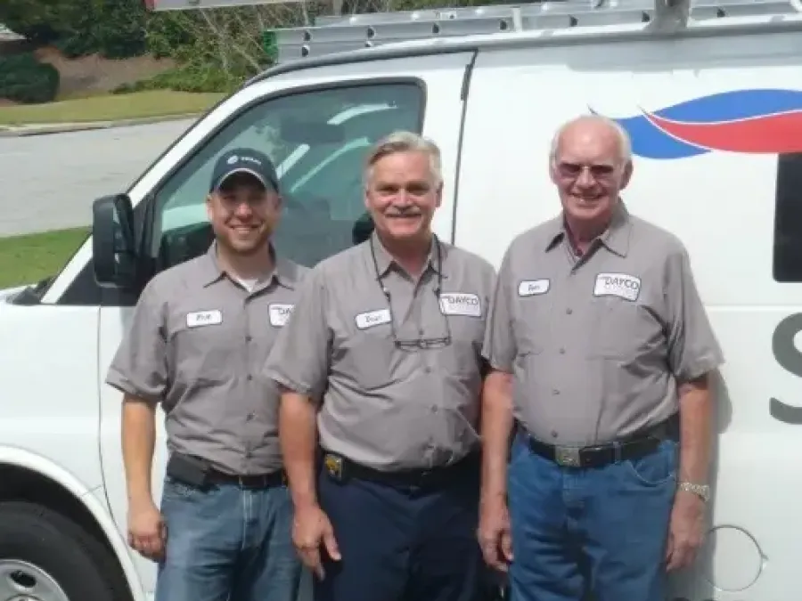 a group of men posing for a photo in front of a truck