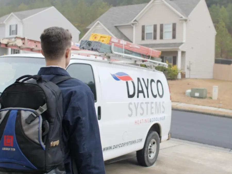 a man with a backpack looking at a white van