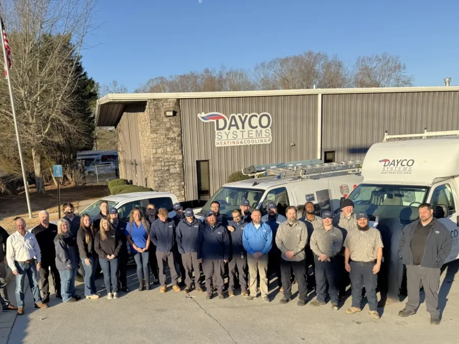 Group photo of Dayco Systems team in front of their office and service vehicles.