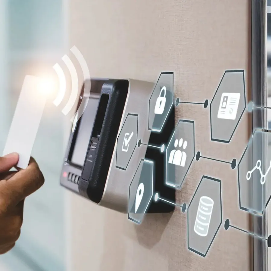 Person holding a card near a digital access control panel with security and data icons in a modern office.