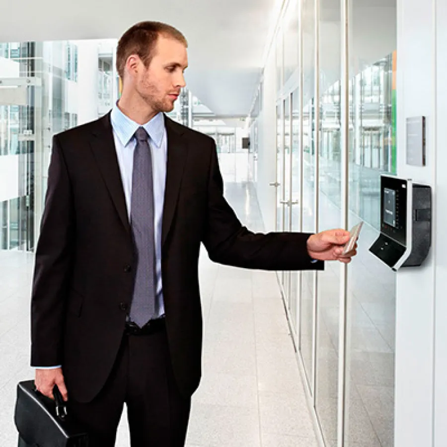 Businessman in suit using access card at modern office building's secure entry point