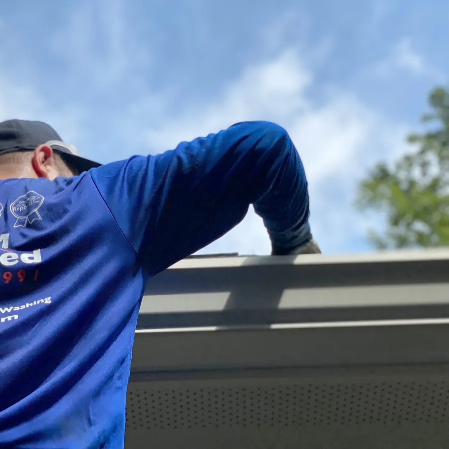 a man cleaning gutters