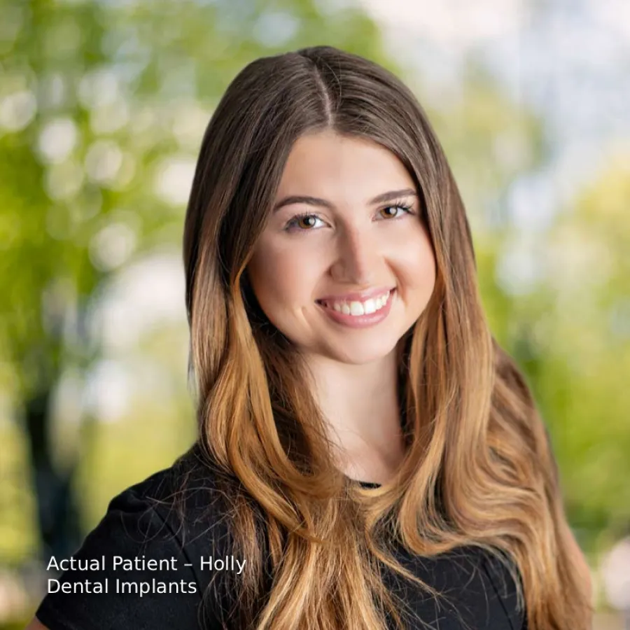 Smiling young woman with long hair outdoors, showcasing dental implant results with natural teeth and bright smile.