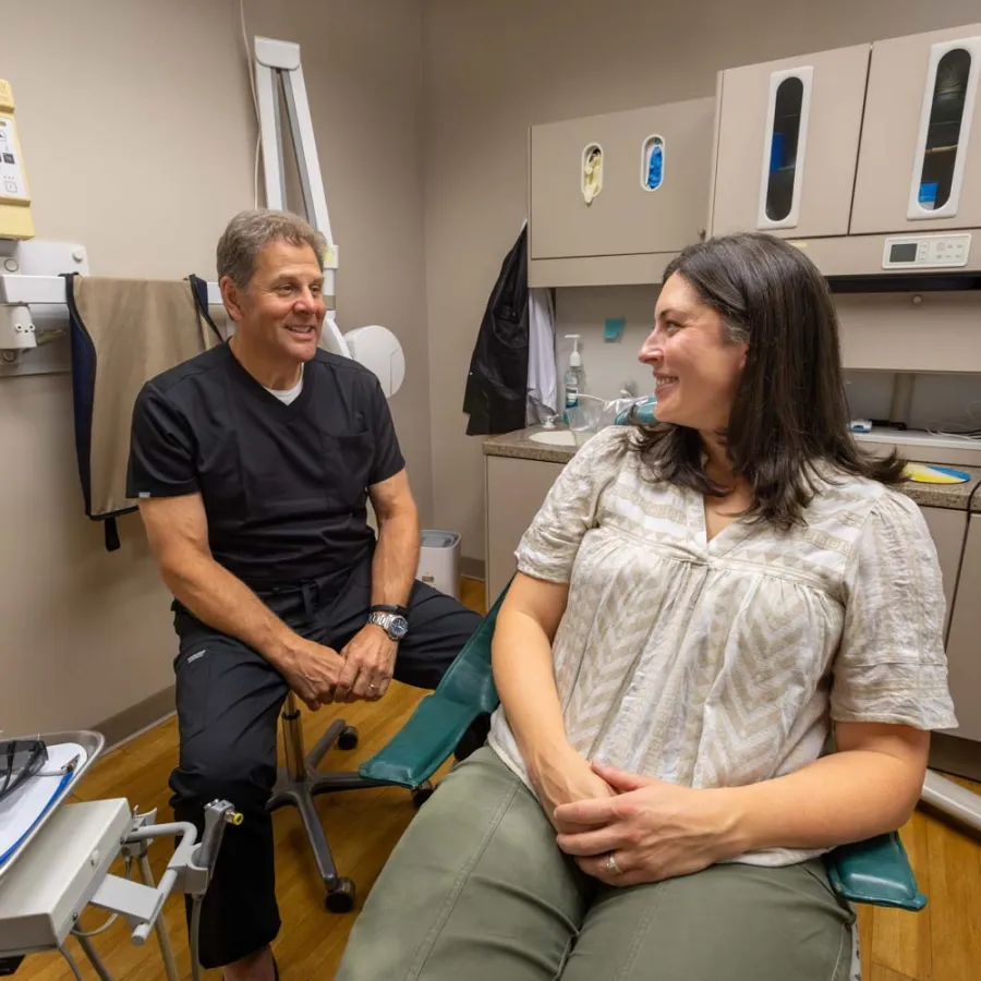 Dentist discussing treatment with female patient in a modern dental office with equipment.