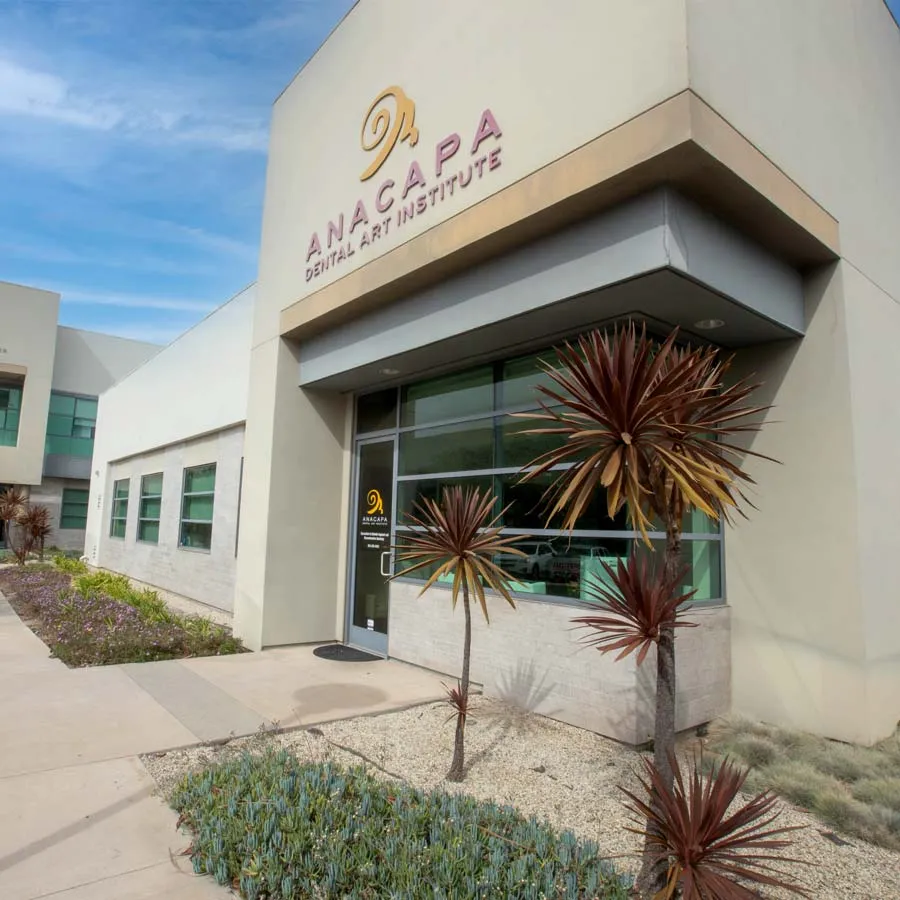 a building with palm trees and a sign on the front