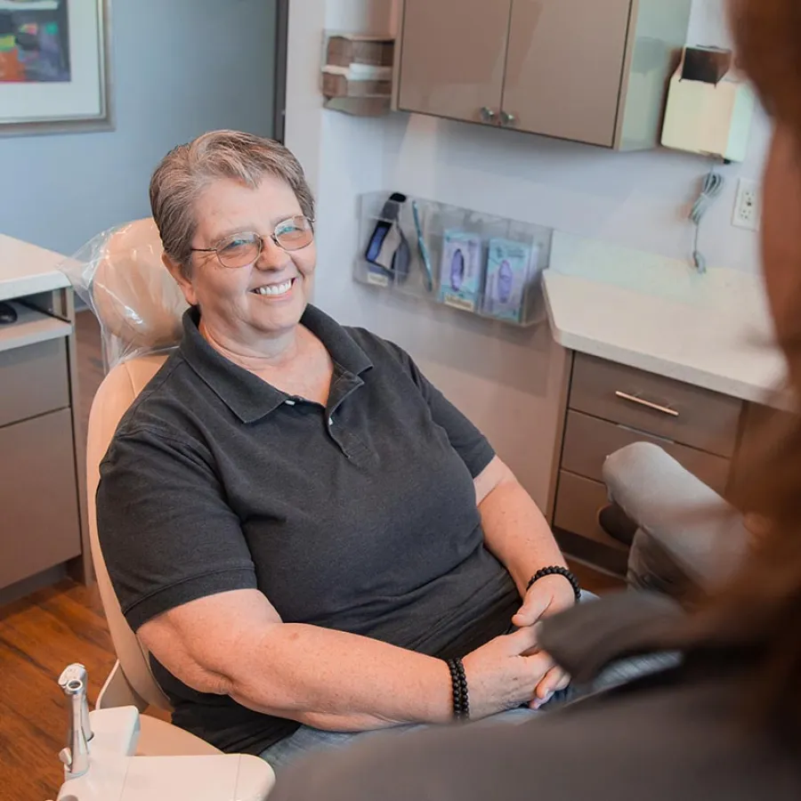 Dentist explaining dental model to patient in a bright modern dental office.