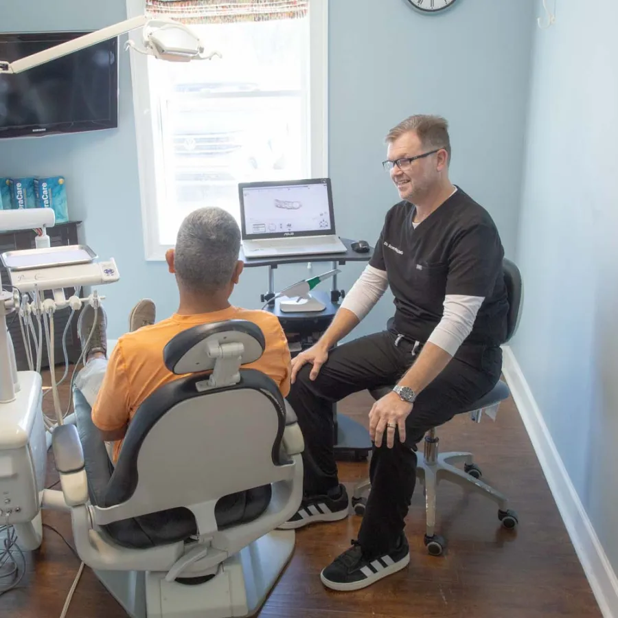 Dr. Scott Fitts chats with a male patient inside his dental office