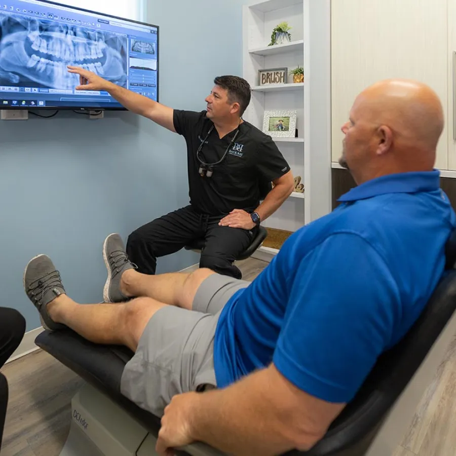 Dr. Jeremy Parker explains dental X-ray on screen to patient