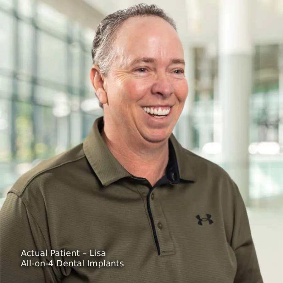 Middle-aged man smiling indoors wearing olive green Under Armour polo shirt with modern office background.