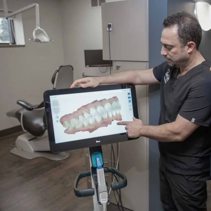 A dentist showing a 3D dental model to a patient in a modern clinic setting.