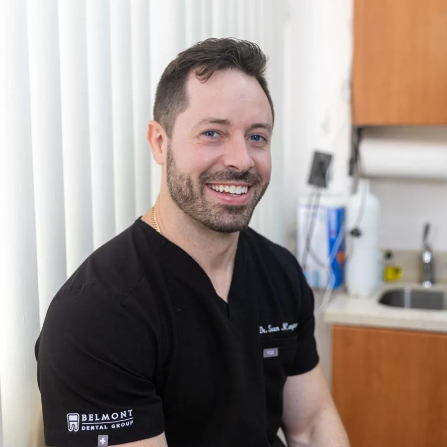Dr. Sean M. Langton in black scrubs inside his dental office
