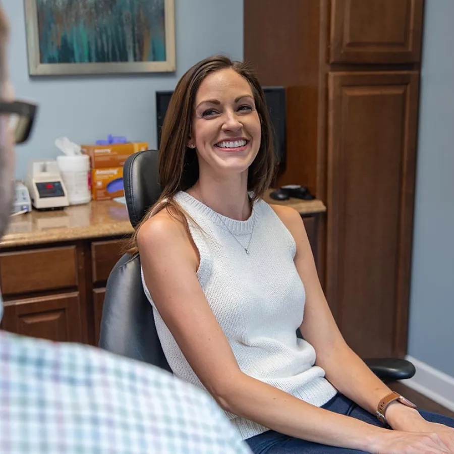 a dark haired patient smiles to Dr. Scott Fitts inside his dental office