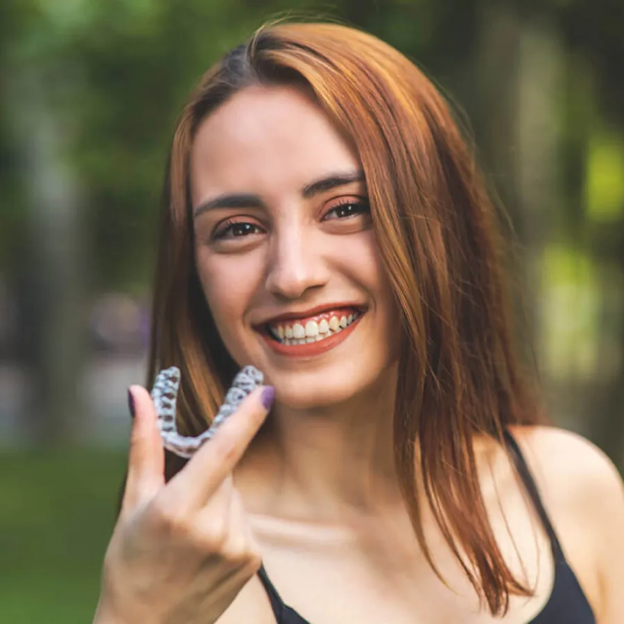 a woman smiling and holding her hand up