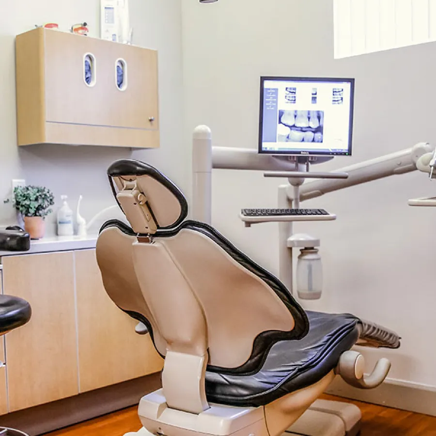 Modern dental clinic interior featuring a patient chair and dental equipment.
