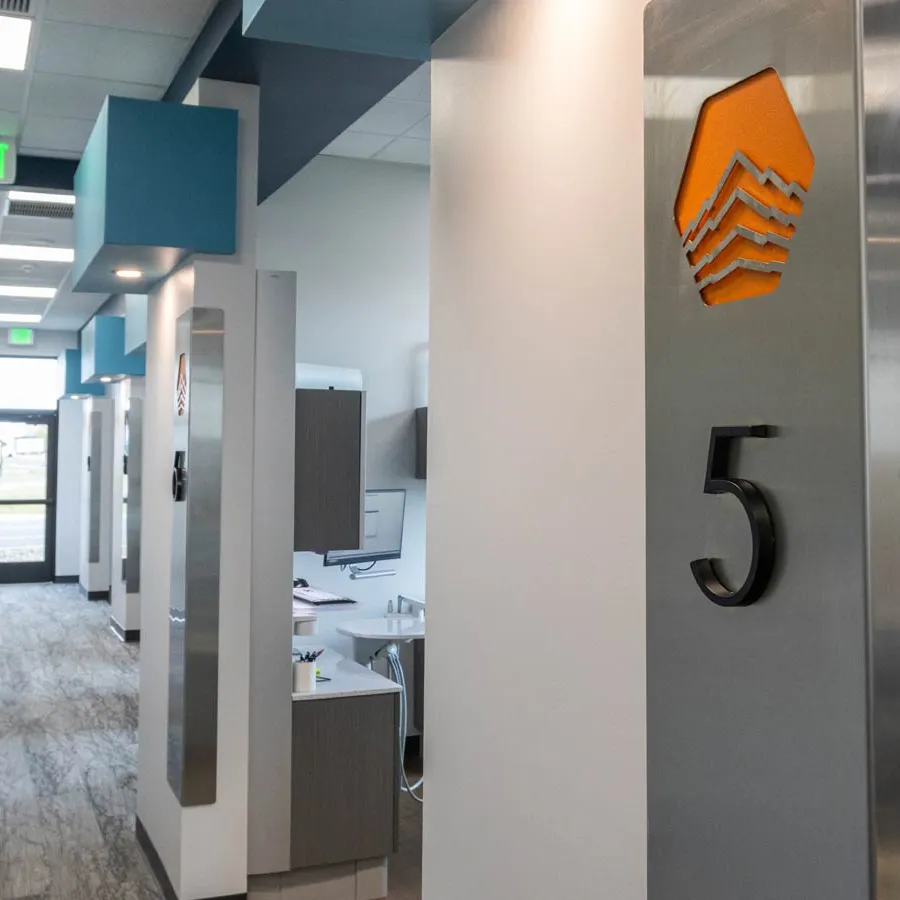 Modern office hallway with gray and blue walls, workstations, and an exit sign, highlighting area number 5.