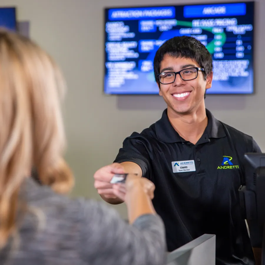 A smiling employee assists a customer at a service desk, showcasing friendly customer service.