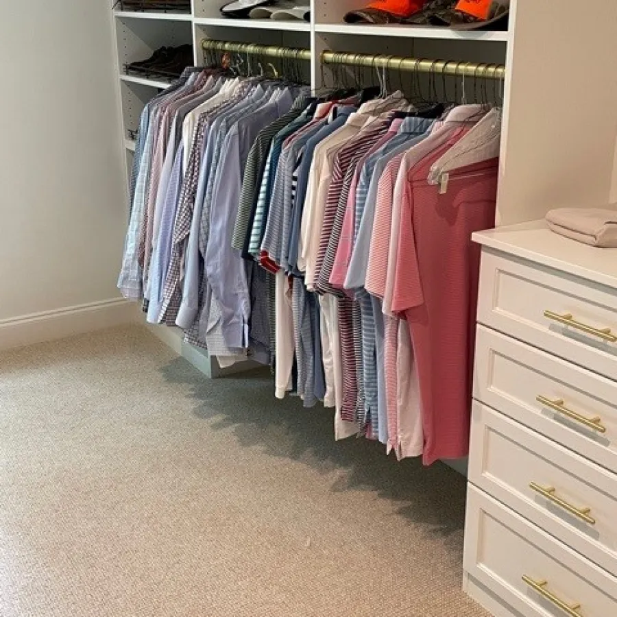 a closet with clothes and a dresser