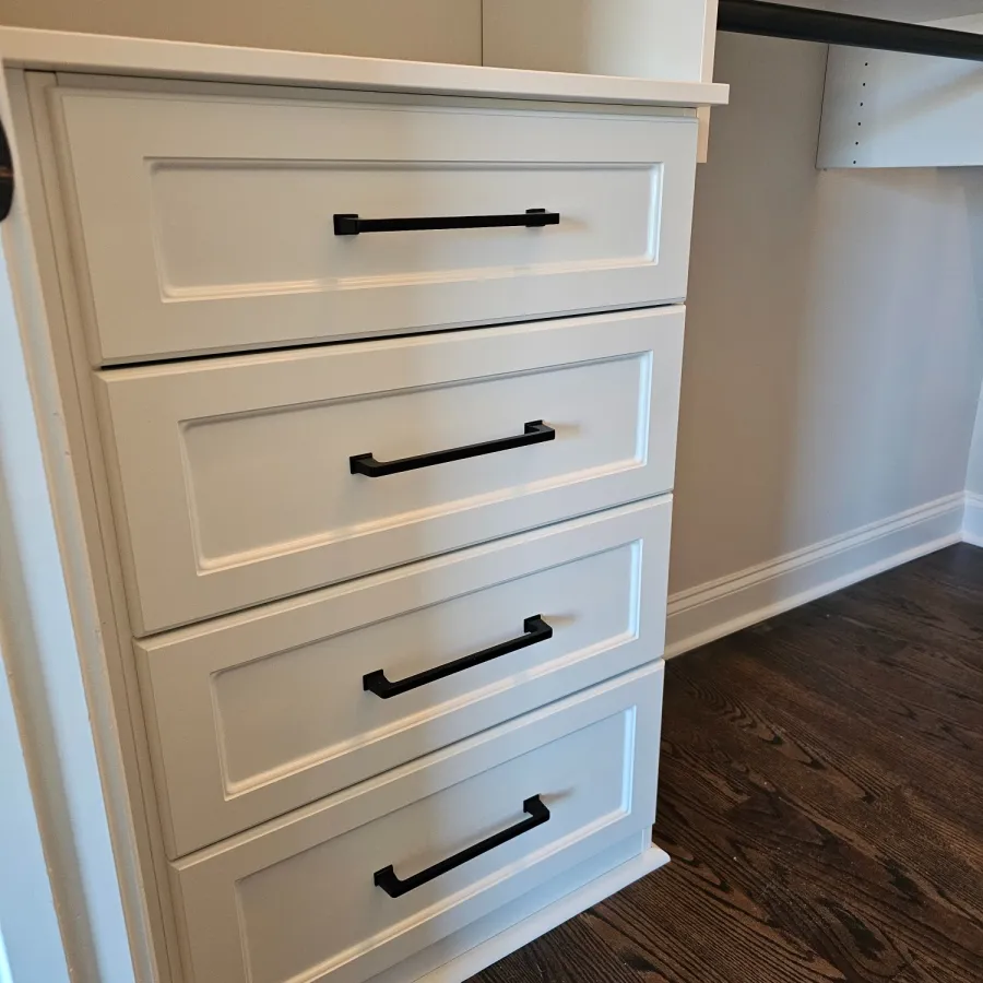 a white cabinet with black handles