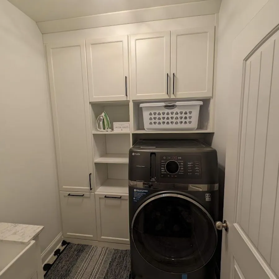 a room with white cabinets and a black speaker