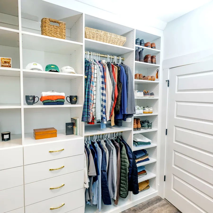 a closet with a white door and shelves with clothes