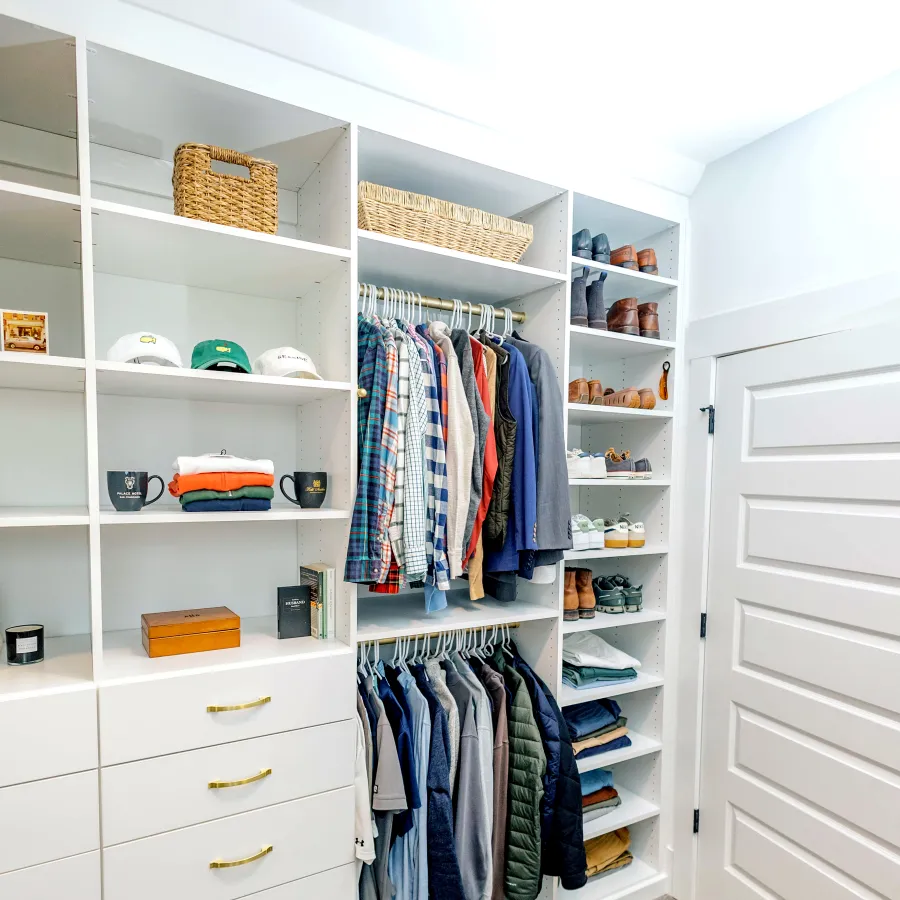 a closet with a white door and shelves with clothes