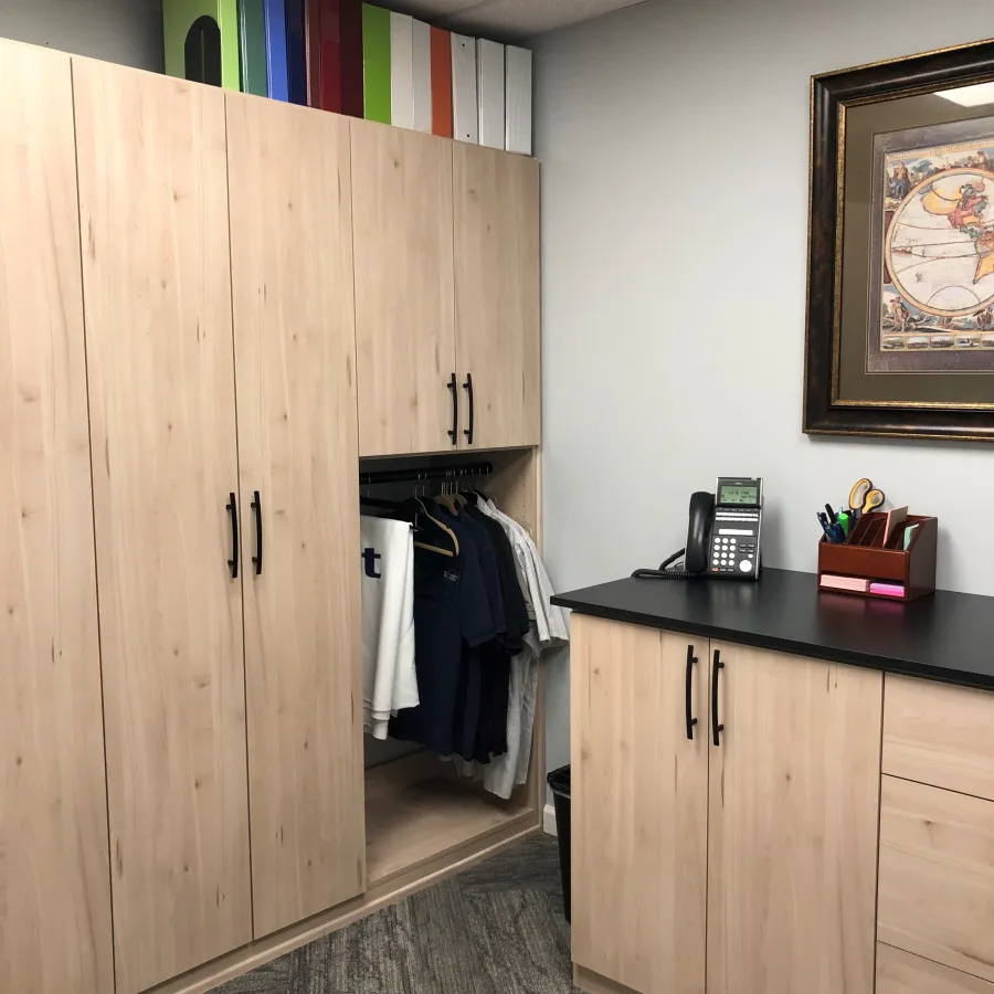 a room with a wood cabinet and a desk with a phone on it