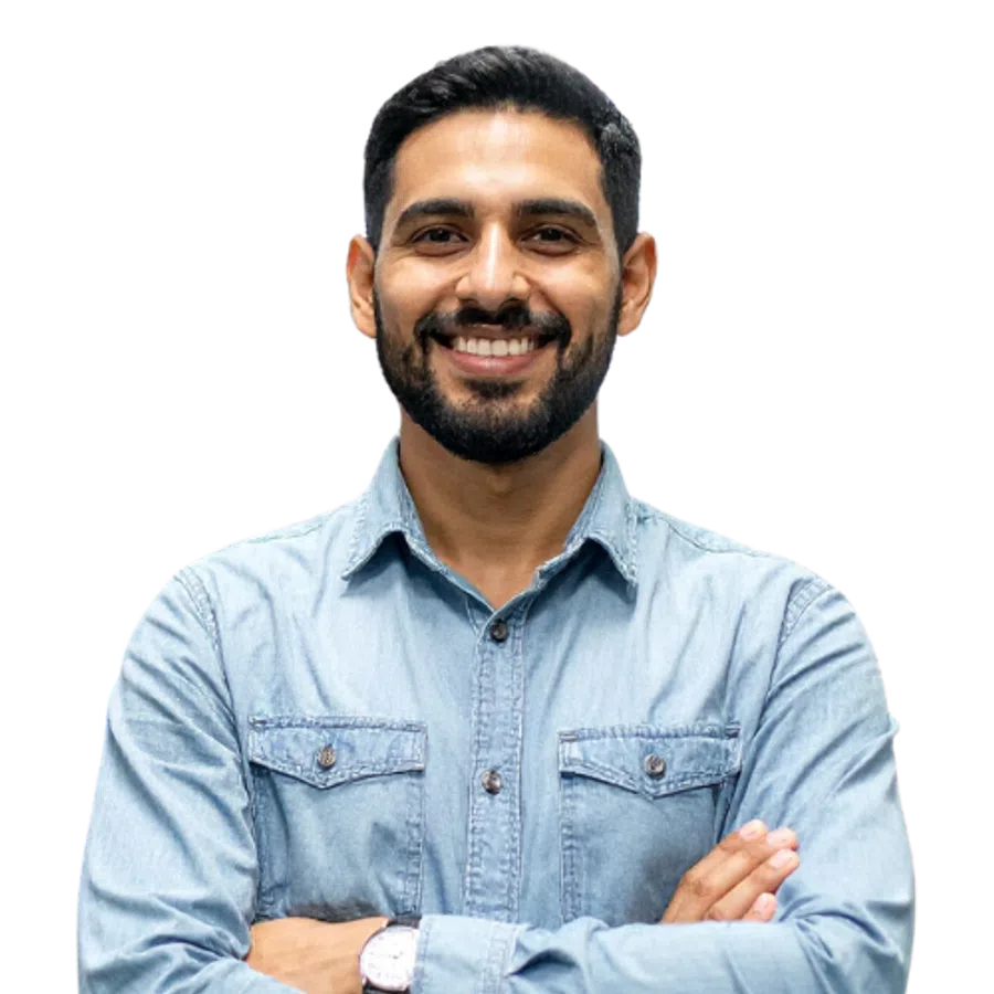 Smiling man with beard and mustache wearing a light blue denim shirt with arms crossed