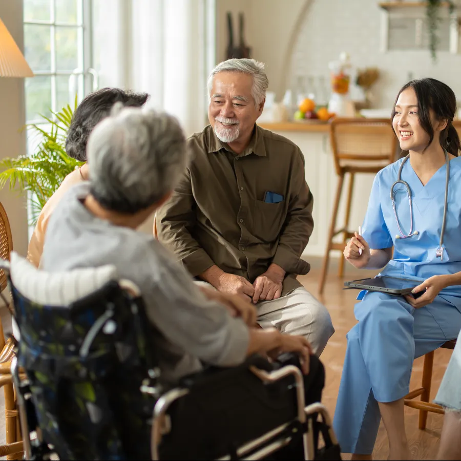 Healthcare professional discussing with elderly patients in a cozy living space.