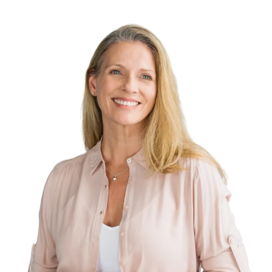 Smiling middle-aged woman with blonde hair wearing a light pink blouse and white shirt, looking confident and approachable.