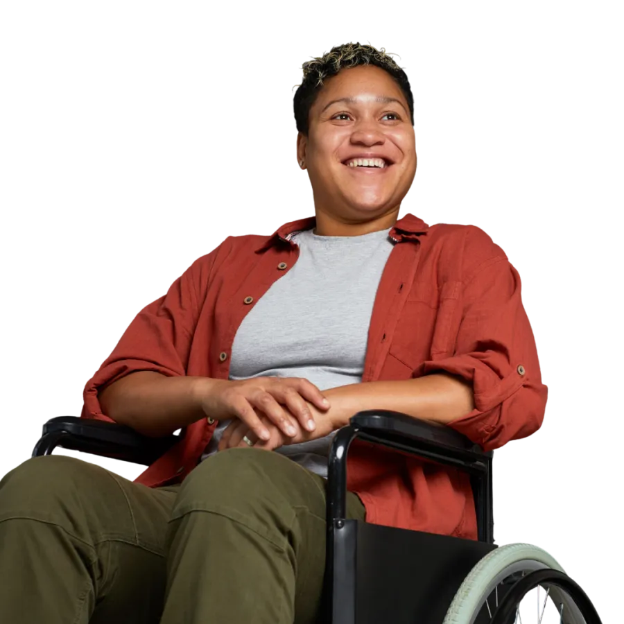 Smiling person in a wheelchair wearing a red shirt and olive pants looking happy and relaxed