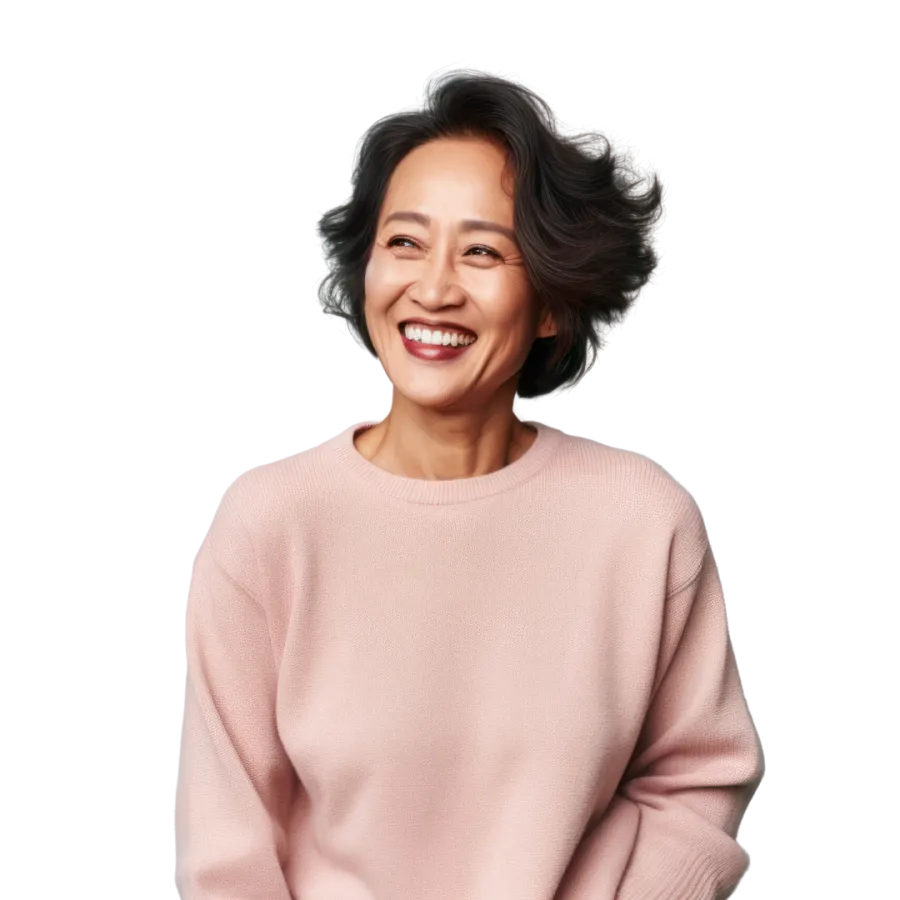 Smiling woman with glasses wearing brown polka dot shirt working on laptop at desk indoors