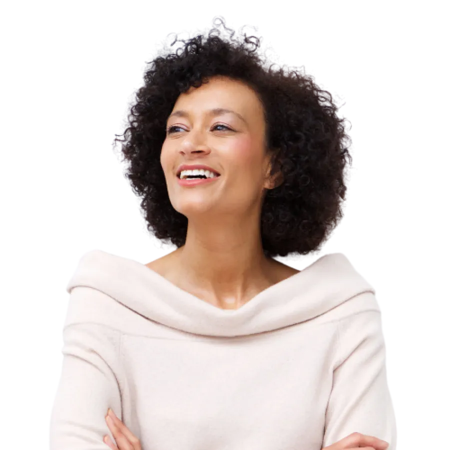Confident woman with curly hair smiling, wearing a white off-shoulder sweater with arms crossed.